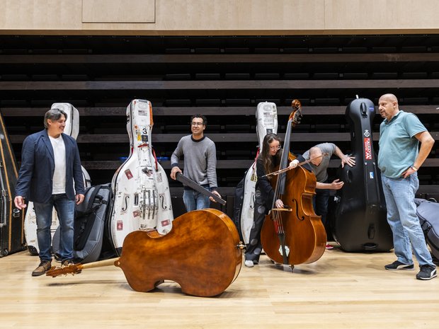 Kontrabass-Spieler*innen und ihre Instrumentenkoffer