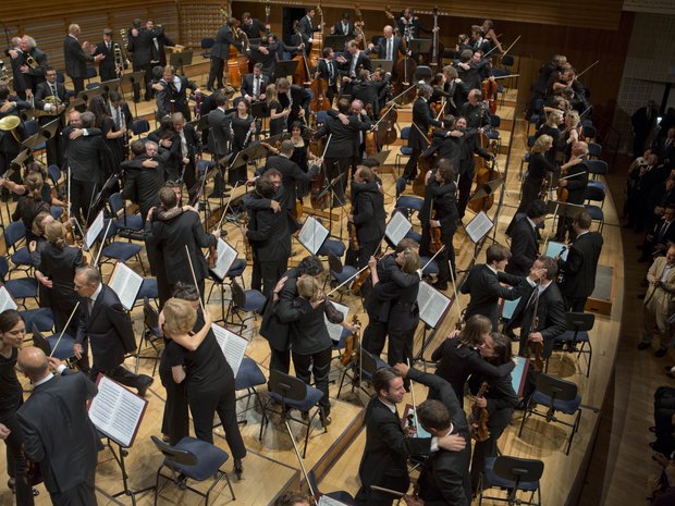 Die Musiker*innen des Lucerne Festival Orchestra umarmen sich nach einem Konzert, 2013